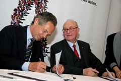 Andreas Treichl (Erste Group) auf der linken Seite und Günter Geyer (VIG) auf der rechten Seite unterzeichnen Kooperationsvertrag